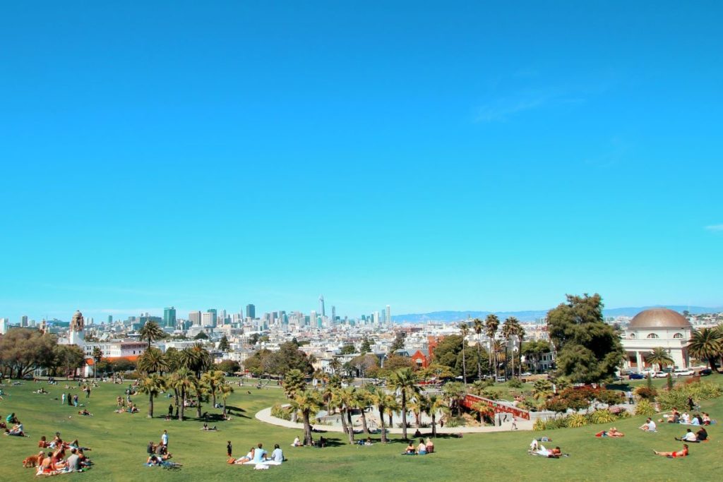 People sit on the grass at Dolores Park in SF.