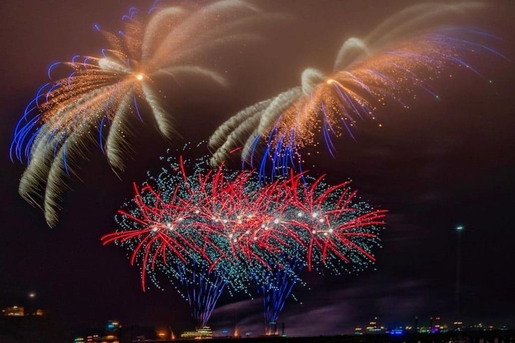 An explosion of red, blue, and yellow fireworks over the SF Bay.