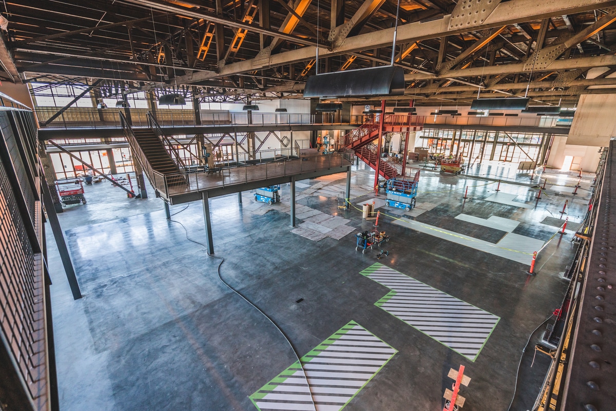 Interior of Building 12 at Pier 70, a large football-size industrial space with concrete floors and exposed steel beams.