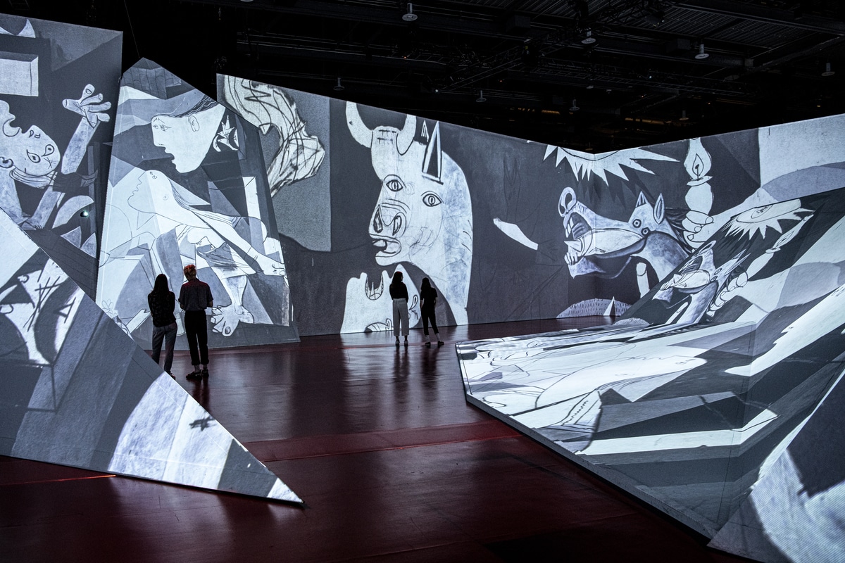 Picasso's 'Guernica' projected on the walls and triangular sculptural pieces at the 'Imagine Picasso' exhibition.