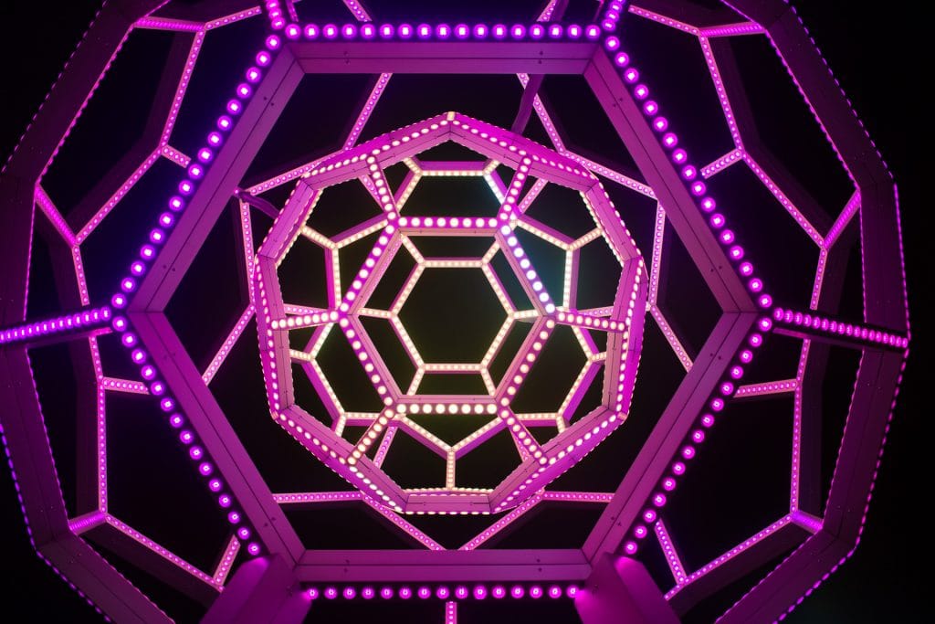 Concentric view of Exploratorium's 'Buckyball' lit in pink and purple colors.