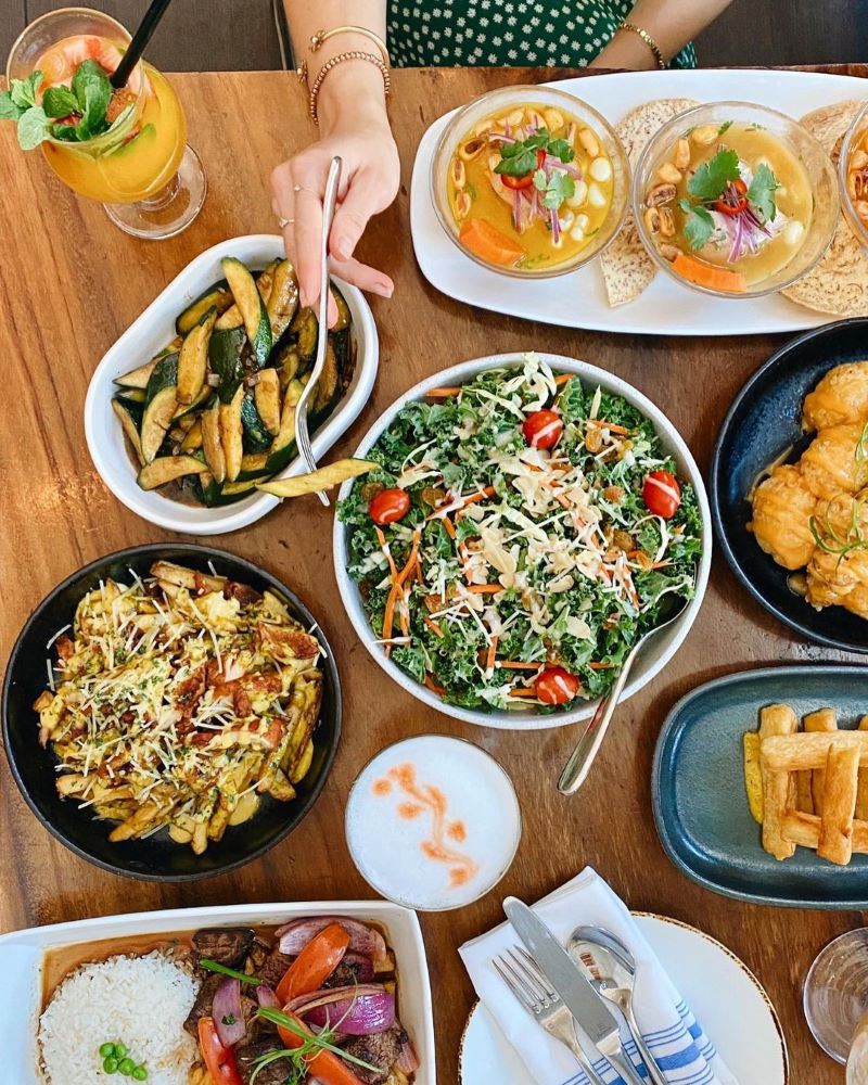 A table spread with a colorful variety of Peruvian dishes.