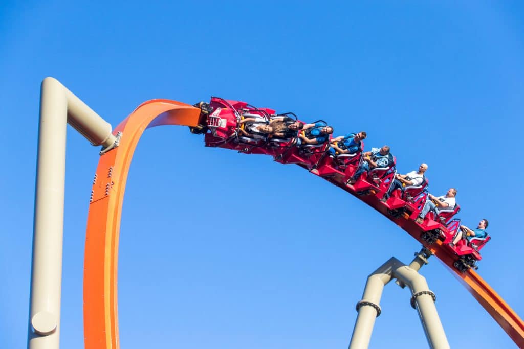 The RailBlazer roller coaster at Great America, showing a red roller coaster car on an orange track against a blue sky.