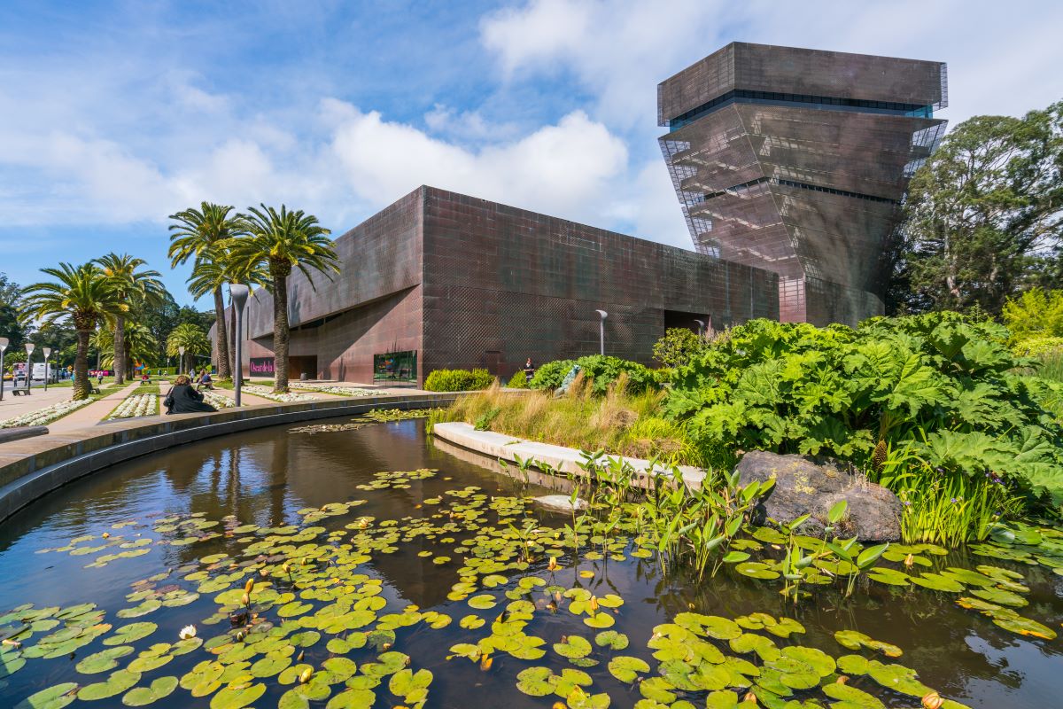 de Young Museum exterior with a lily pond in the foreground.