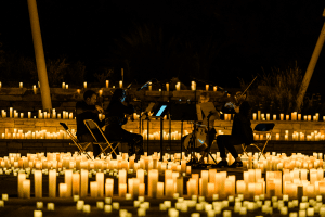 A string quartet is surrounded by candlelight