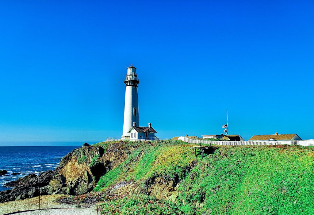 Pigeon Point Lighthouse against a clear blue sky.