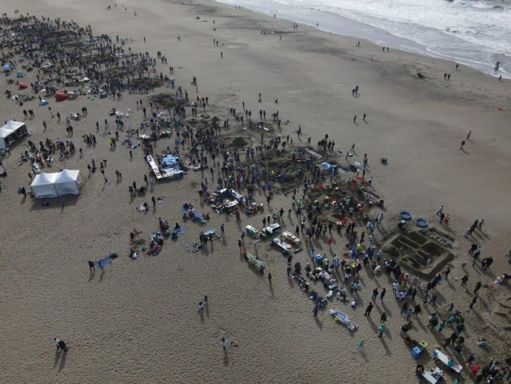 Drone shot showing thousands of people working on sandcastles at the Leap Sandcastle Classic at Ocean Beach