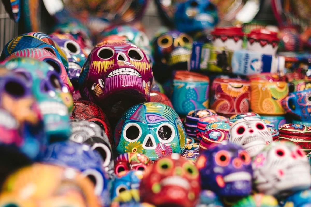 A pile of colorful painted calaveras, or skull sculptures
