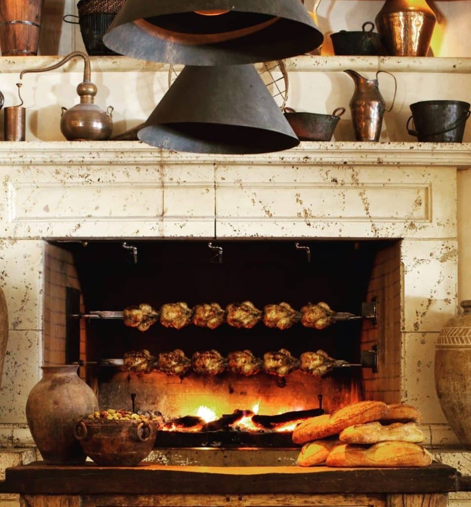 Two spits filled with chickens roast over an open fireplace at Kokkari Estiatorio.