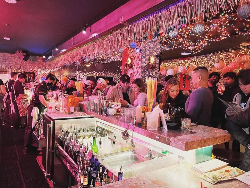 Crowded Sippin' Santa holiday bar decorated with Christmas lights