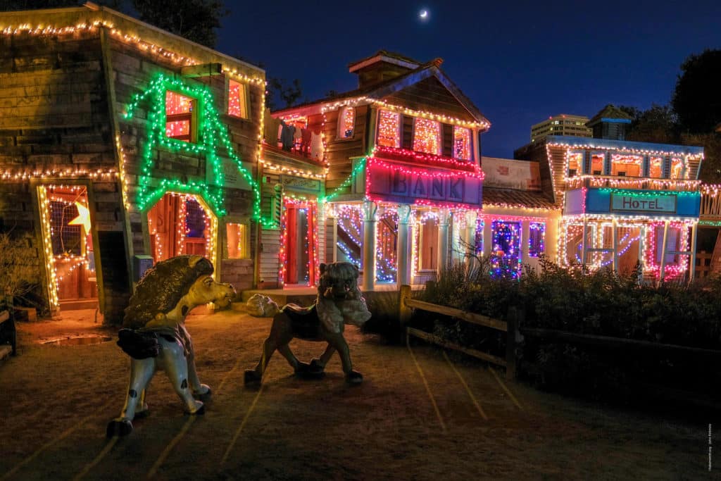 A life-sized replica of an old west town decorated with holiday lights.