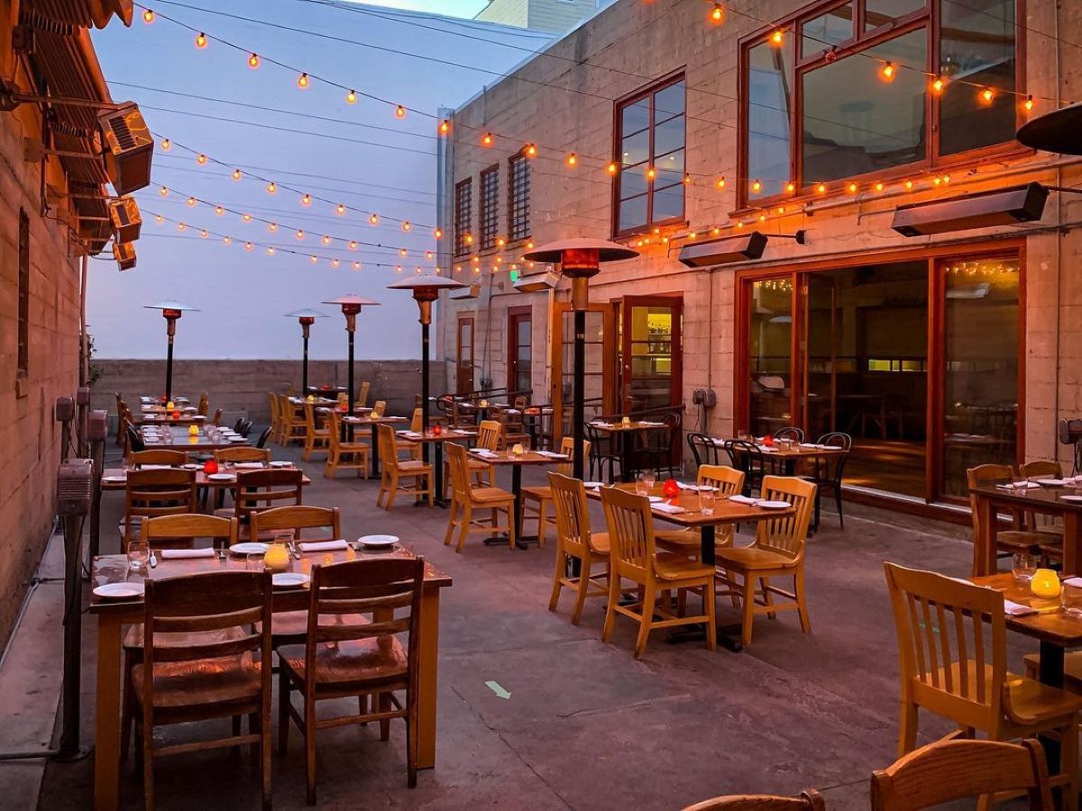 Outdoor patio restaurant with string lights at dusk.