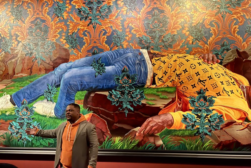 Kehinde Wiley standing before one of his paintings