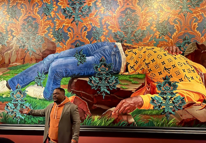 Kehinde Wiley speaking in front of one of his paintings at de Young museum