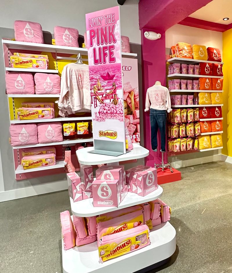 A pink Starburst display with Starburst-themed clothing and merchandise.