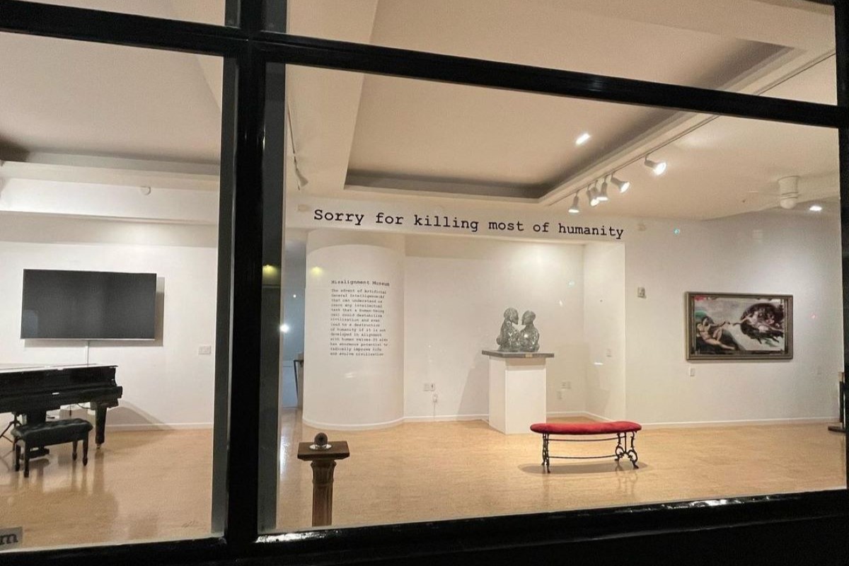 Interior of Misalignment Museum with "Sorry for killing most of humanity" written on the wall.