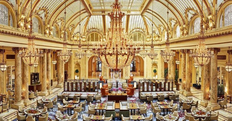 The Palace Hotel's dining room with multiple golden chandeliers beneath a large ornate skylight.