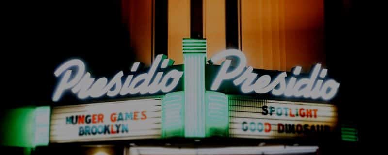 Presidio Theater marquee showing neon sign and showtimes.
