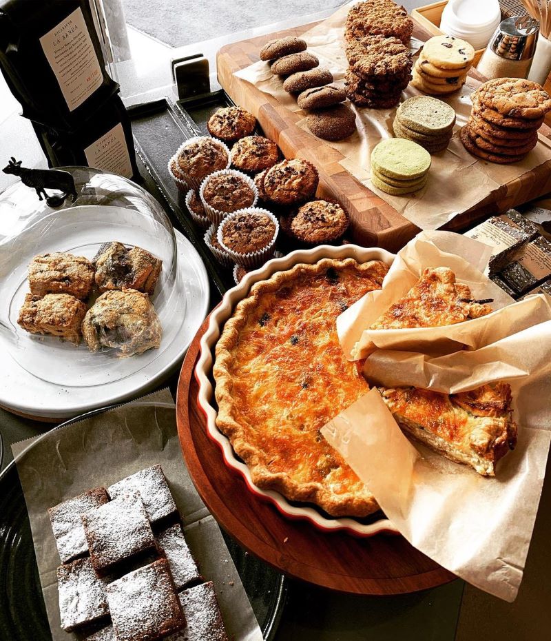 A spread of baked goods including quiche, muffins, cookies, and brownies at Whole Cakes in SF.