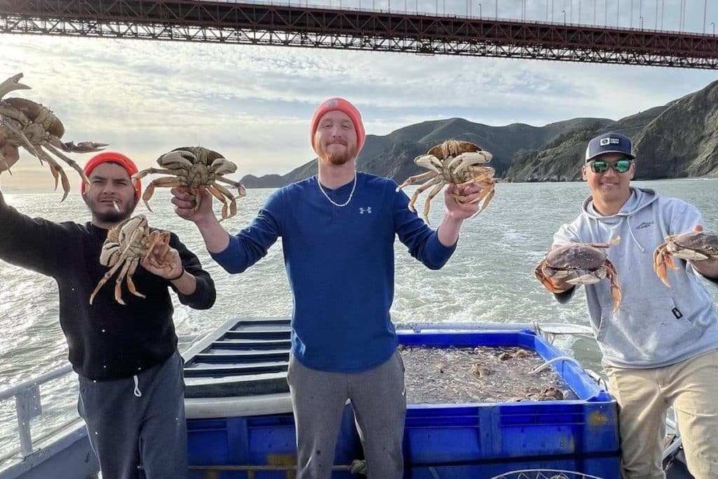 Men holding crabs on a boat