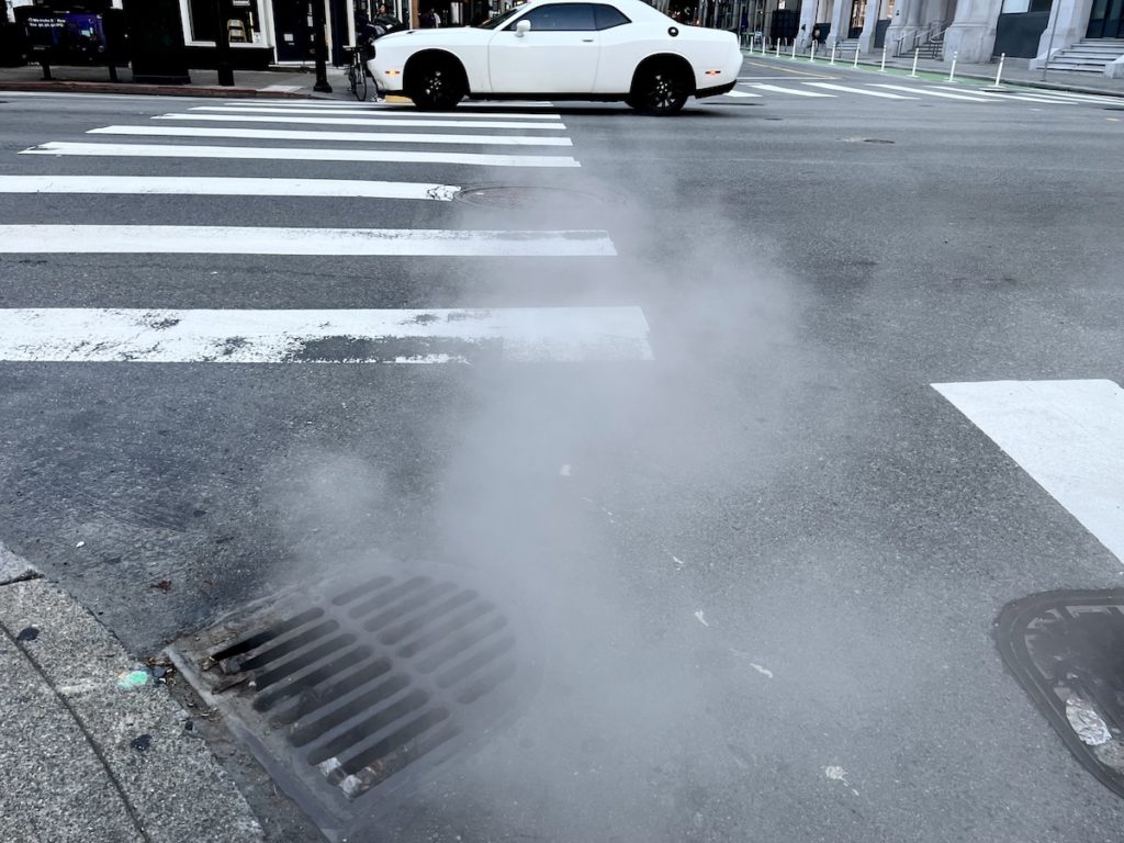 Steam escaping from grate on street corner SF