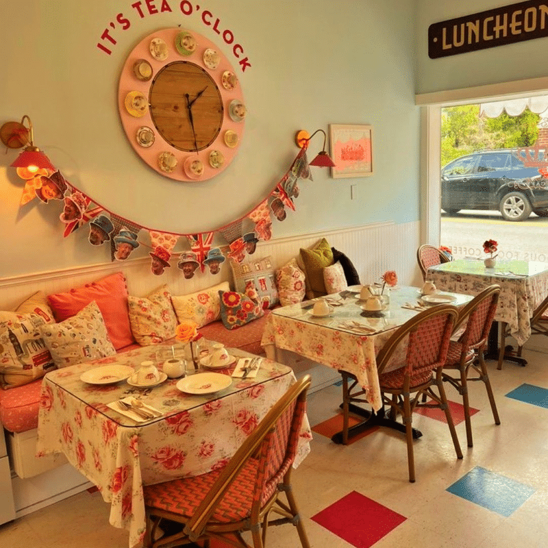 Two tables set up for a tea service in a colorful pastel dining room.