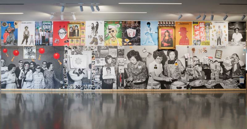 Michael Jang's "The Whole Story" mural with black and white photographs of Asian-American families contrasted with colorful posters.