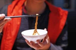 Customer enjoying noodles with chopsticks 