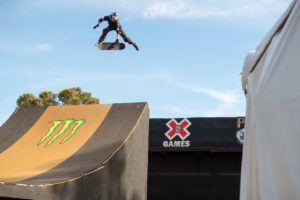 A skater does tricks mid-air at an X Games event