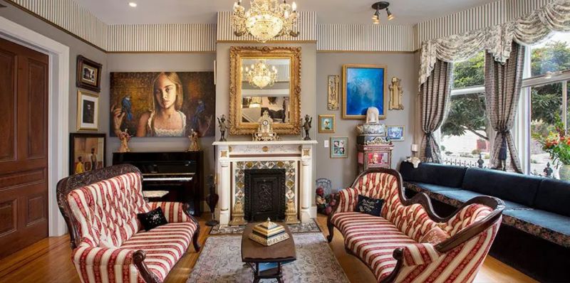 Sitting room at Noe's Nest with ornate gold decorations and two striped vintage sofas.
