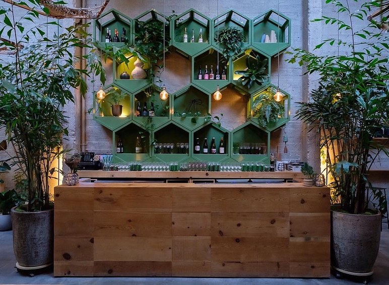 bar with green shelves and wine glasses.