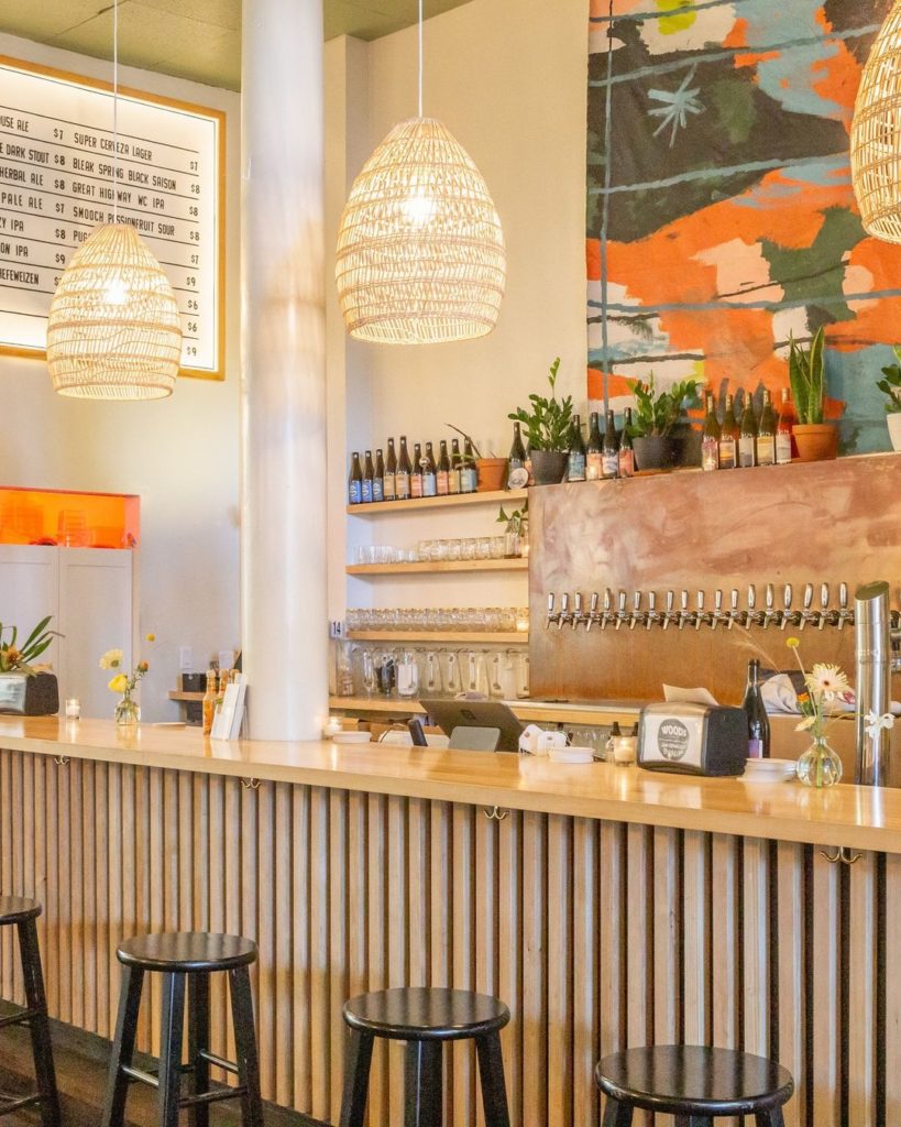 a bright natural wine bar in sf with stools and colorful art.