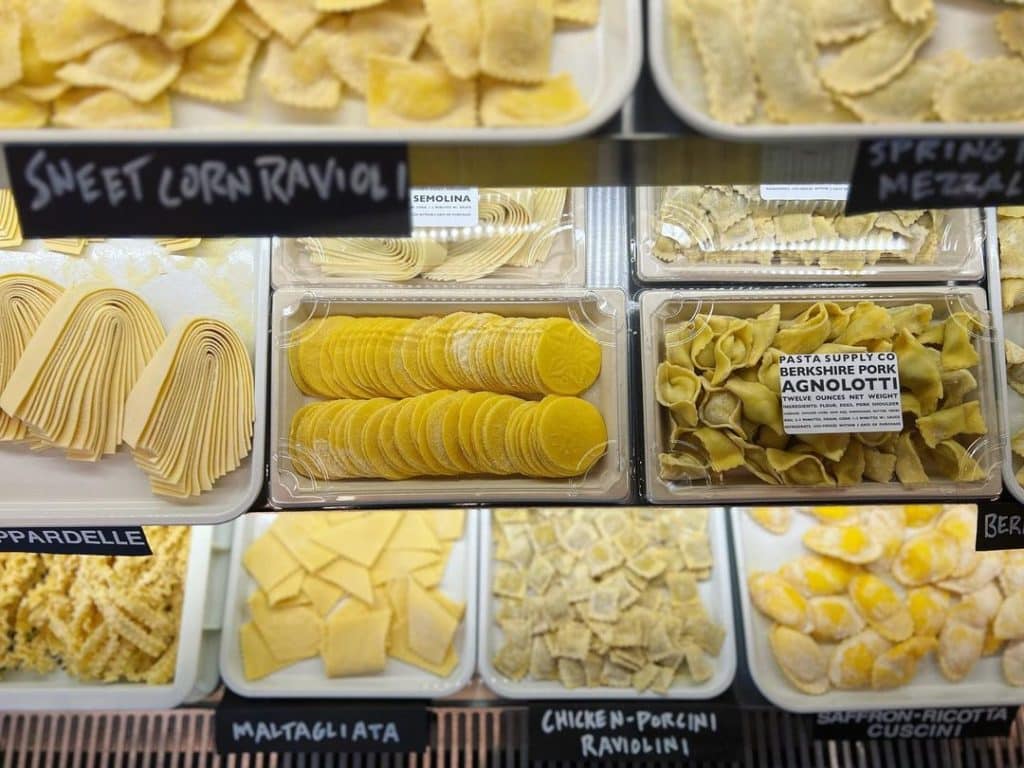 Various handmade pastas are arranged in a deli case at Pasta Supply CO.