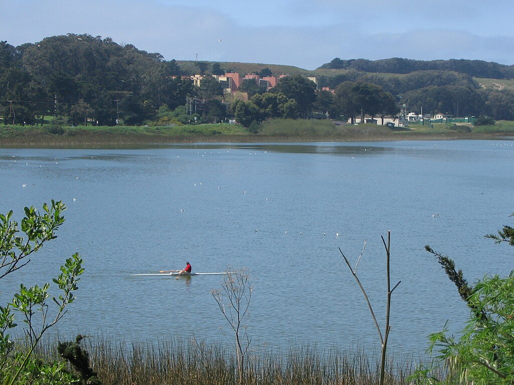A person sits in a kayak at Lake Merced