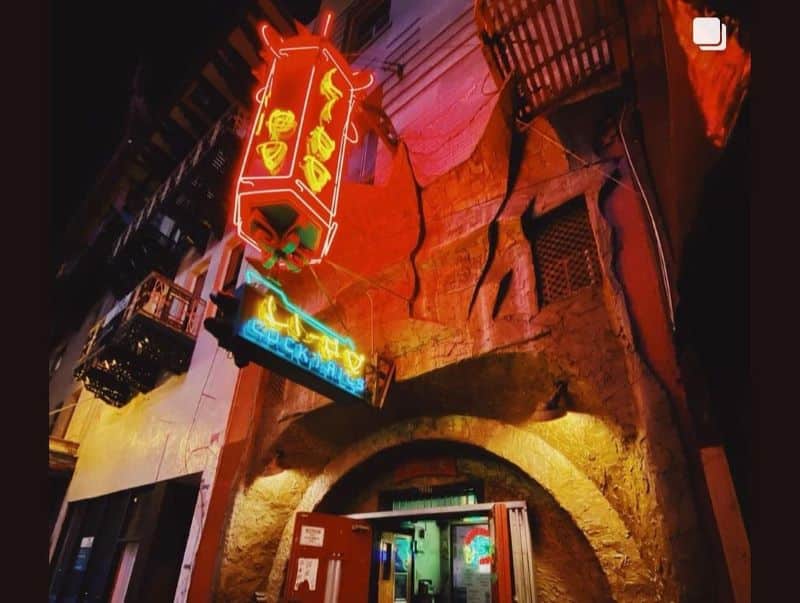 Exterior of Li Po Cocktail Lounge with neon sign and faux rock wall.