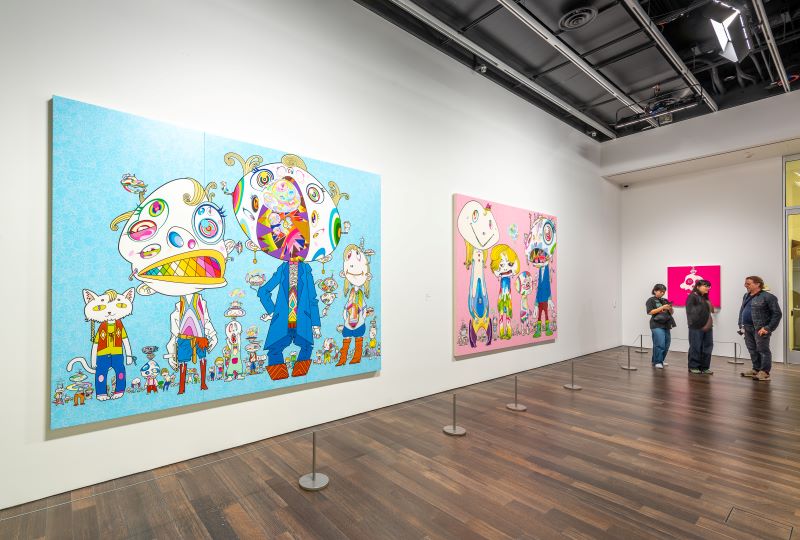 Two monster paintings by Takashi Murakami, one with a blue motif and the other with pink.