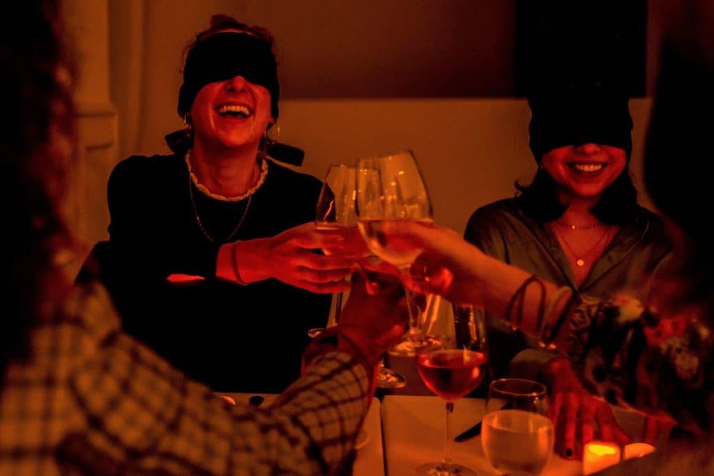Friends saying cheers at the 'Dining in the Dark' experience.