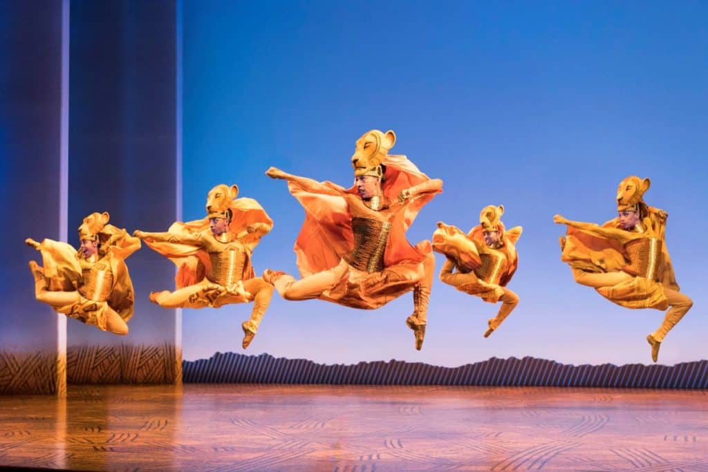 Actors perform a dance as the lionesses in The Lion King.